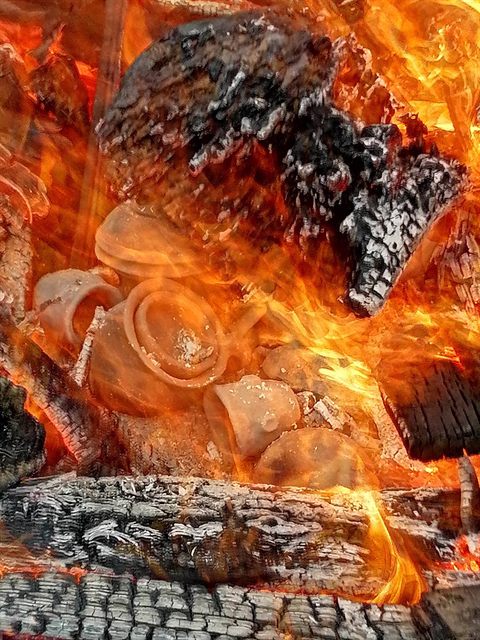 Vase mici de lut printre flăcări și jar